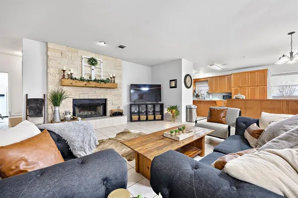 a living room with furniture a chandelier and a dining table with wooden floor