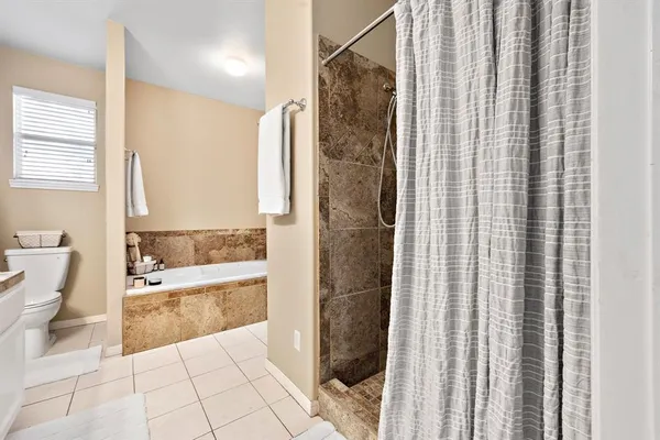 a spacious bedroom with a bed and a chandelier