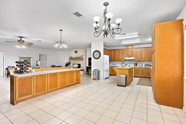 a large kitchen with stainless steel appliances granite countertop a stove a sink and a refrigerator