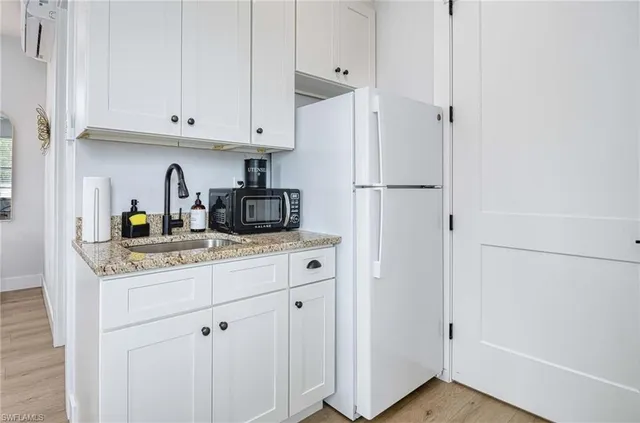a kitchen with stainless steel appliances white cabinets and a refrigerator