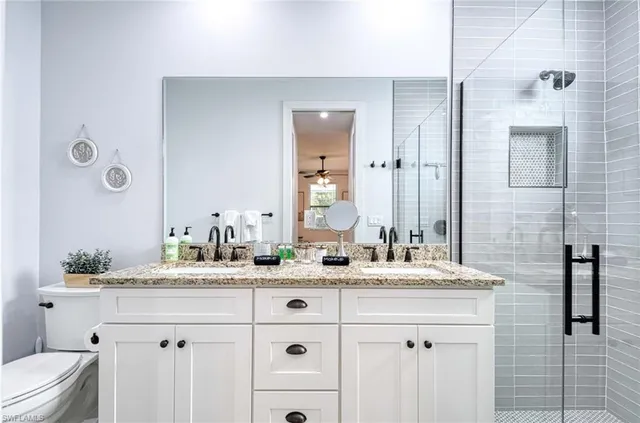 a bathroom with a double vanity sink mirror and toilet