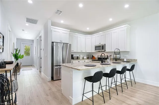 a kitchen with refrigerator and chairs