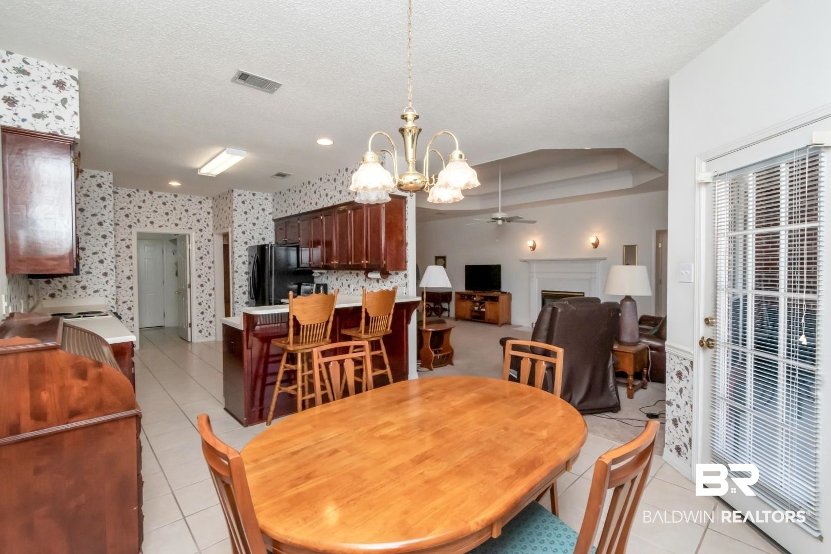 1032 Cross Gates Place Mobile, AL 36609 - Photo 9 of 34 Dining space with hanging lights, ceiling fan, a fireplace, light tile patterned floors, and a textured ceiling
