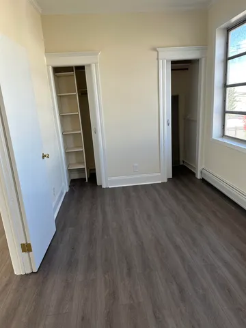 an empty room with wooden floor and a window