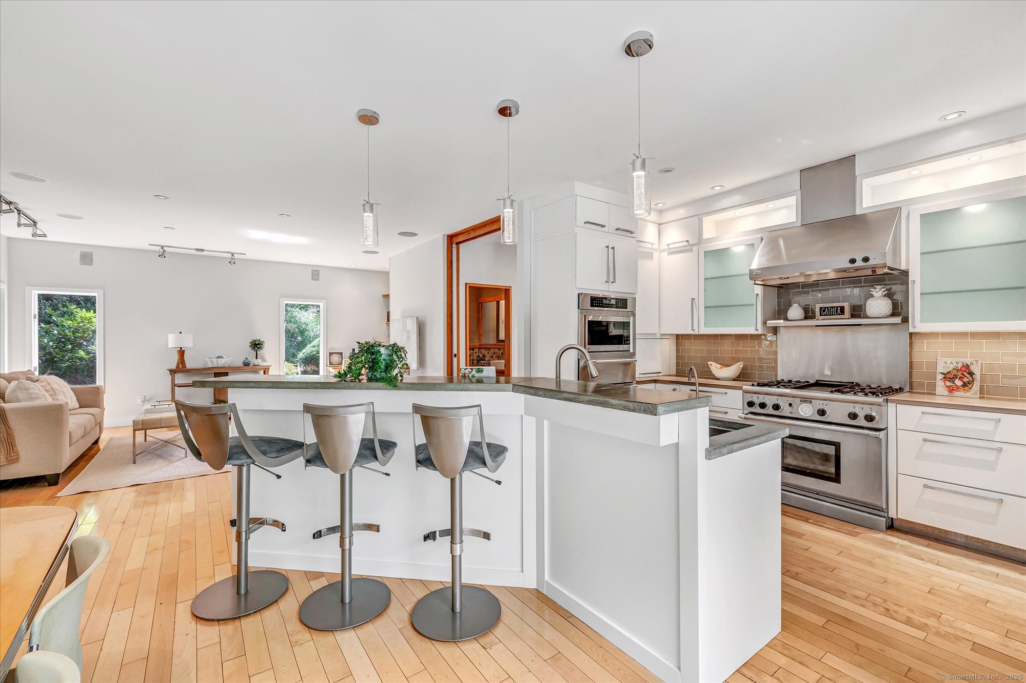 19 A Darbrook Road Westport, CT 06880 - Photo 18 of 40 a kitchen with stainless steel appliances a dining table chairs stove and white cabinets