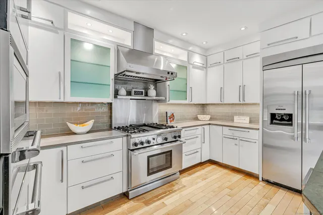a kitchen with white cabinets and appliances
