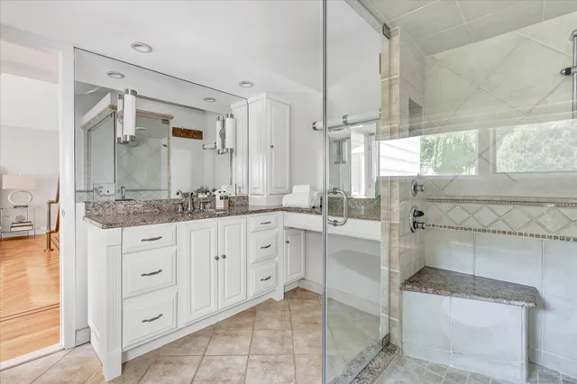 a spacious bathroom with a granite countertop sink and a mirror
