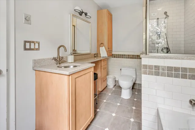 a bathroom with a sink a toilet and shower