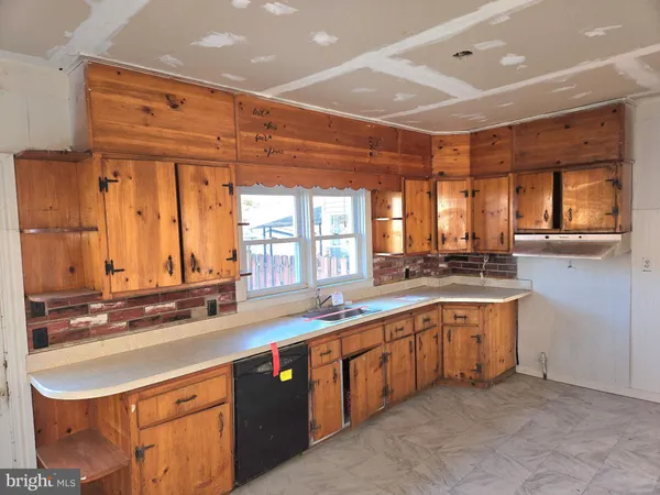 a large kitchen with stainless steel appliances a sink and cabinets