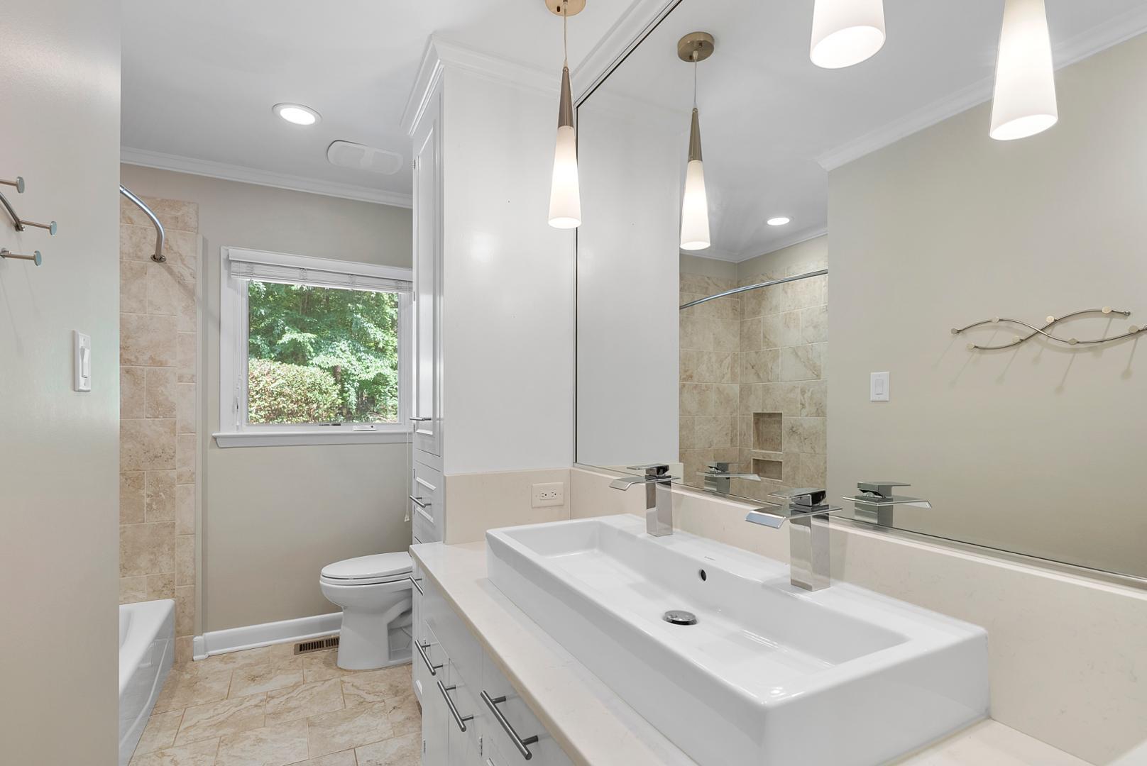 1605 Ridge Road Raleigh, NC 27607 - Photo 26 of 36 a bathroom with a sink a toilet a mirror and a tub