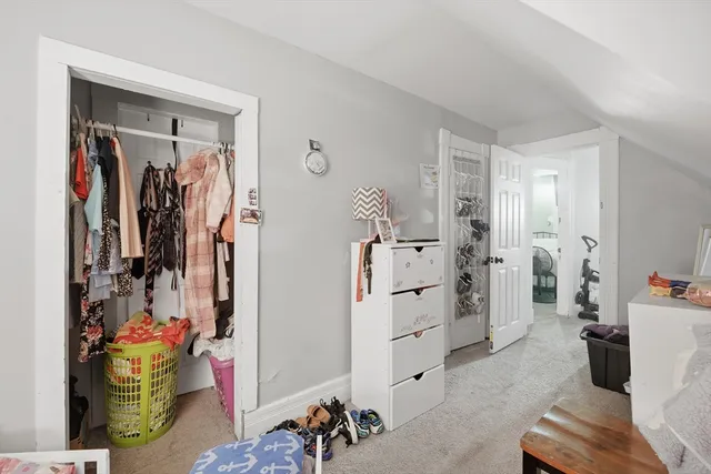a view of walk in closet with clothes and shoes