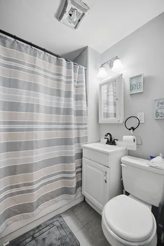 a bathroom with a sink a toilet and shower curtain