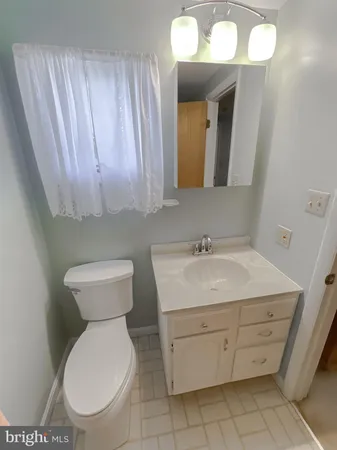 a bathroom with a toilet a sink and mirror