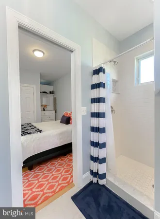 a bedroom with a bed and a lamp on dresser