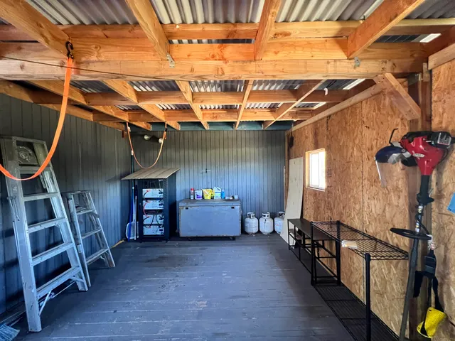 a view of an empty room with wooden floor and furniture