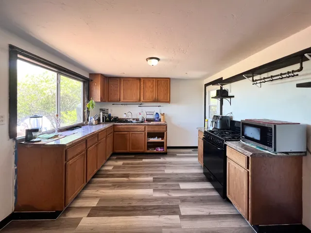 a kitchen with stainless steel appliances granite countertop a stove a sink and a refrigerator