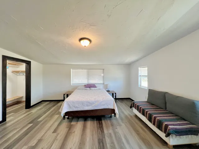 a bedroom with a bed and wooden floor