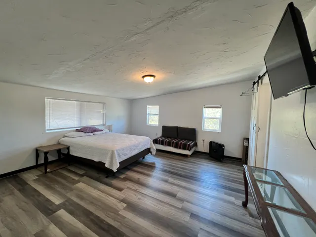 a bedroom with a bed and a flat tv screen on dresser
