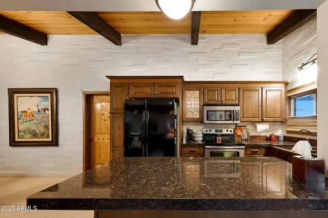 a kitchen with stainless steel appliances granite countertop a stove top oven a sink a counter space and cabinets