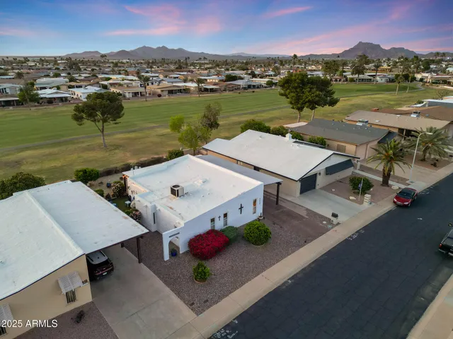 a view of a house with a cars park side of a road