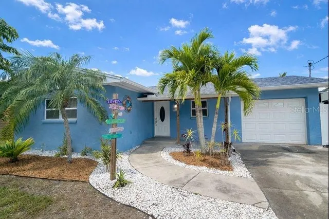 a vase of flowers sitting on a floor in front of a house