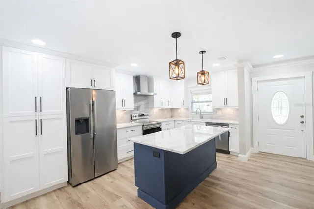 a kitchen with a refrigerator a sink and dishwasher with wooden floor