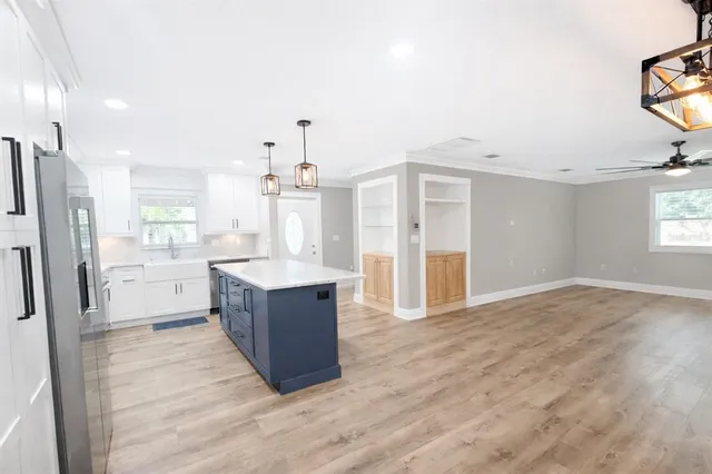 a kitchen with stainless steel appliances kitchen island granite countertop a refrigerator and a sink