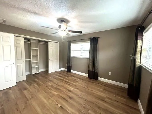 an empty room with windows and closet