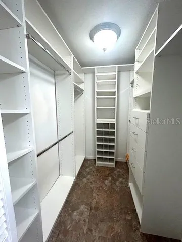 a view of walk in closet with empty racks