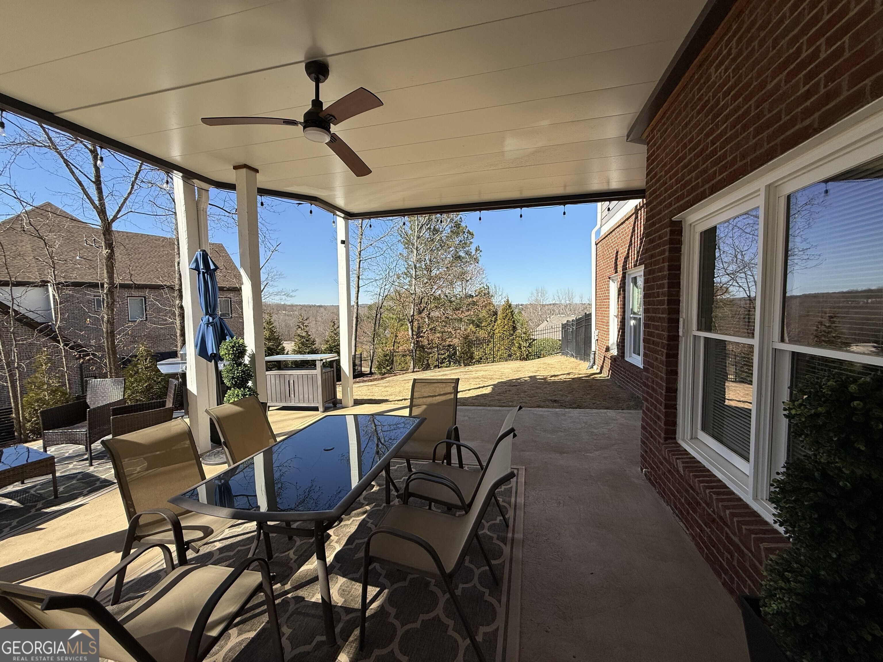 990 Chateau Forest Road Hoschton, GA 30548 - Photo 68 of 117 a view of a patio with table and chairs and floor to ceiling window