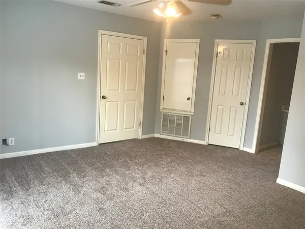 an empty room with windows and closet