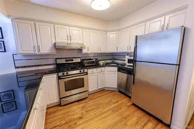 a kitchen with a refrigerator stove and white cabinets