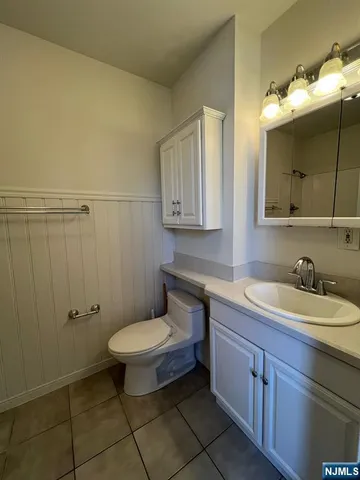 a bathroom with a double vanity sink mirror and toilet