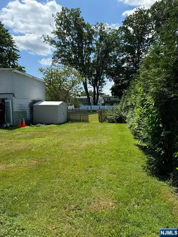 a view of a pool with a big yard and large trees