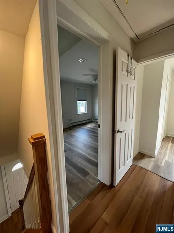 a view of a hallway with wooden floor and staircase