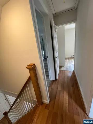 a view of a hallway with wooden floor and staircase