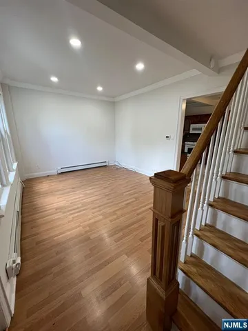 a view of a livingroom with wooden floor and staircase