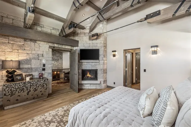 a spacious bedroom with a bed couch and a fireplace