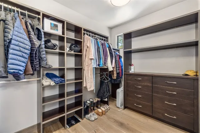 a view of walk in closet with clothes and shoes