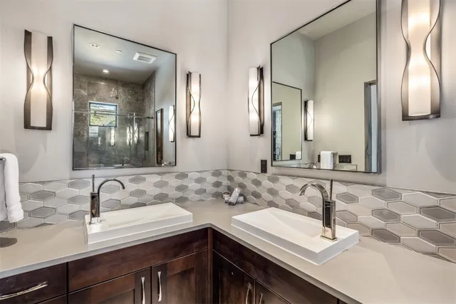 a bathroom with double sink and a mirror