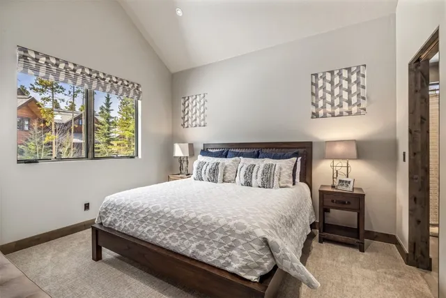 a bedroom with a bed a wall painting and a lamp