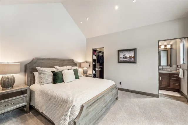 a bedroom with double bed and a refrigerator