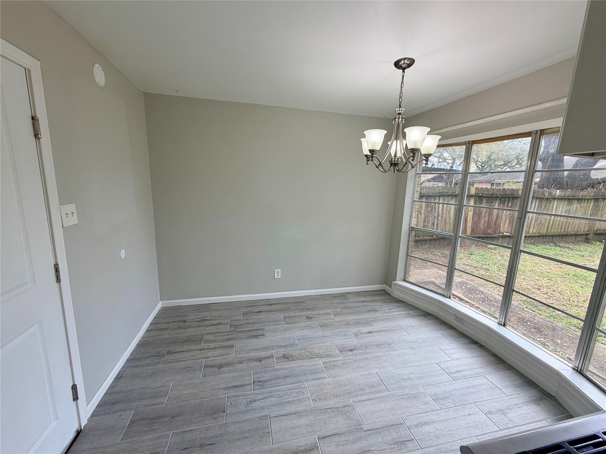 7876 Bender Road Humble, TX 77396 - Photo 13 of 28 a view of an empty room with wooden floor and a window