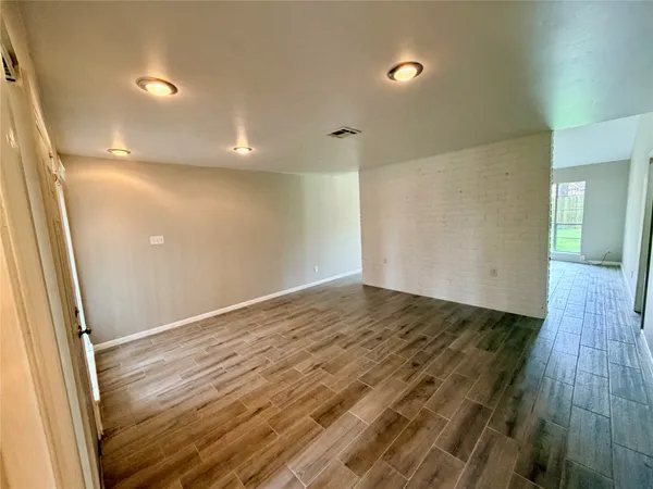 a view of an empty room with a fireplace and a window