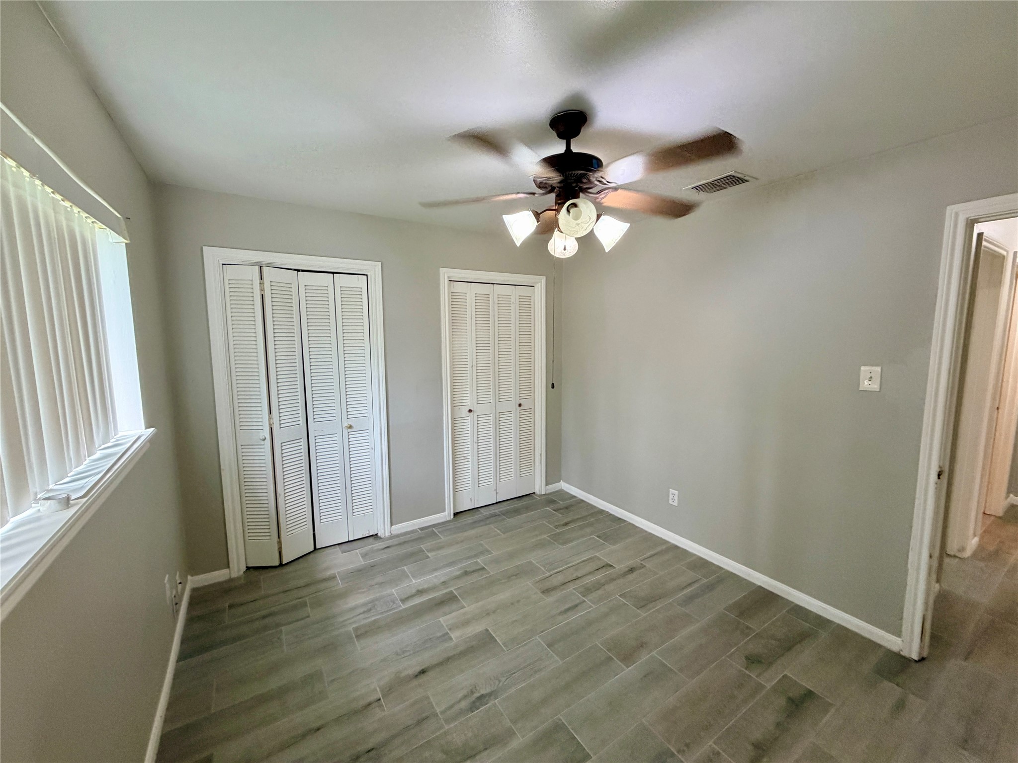 7876 Bender Road Humble, TX 77396 - Photo 21 of 28 an empty room with wooden floor fan and windows