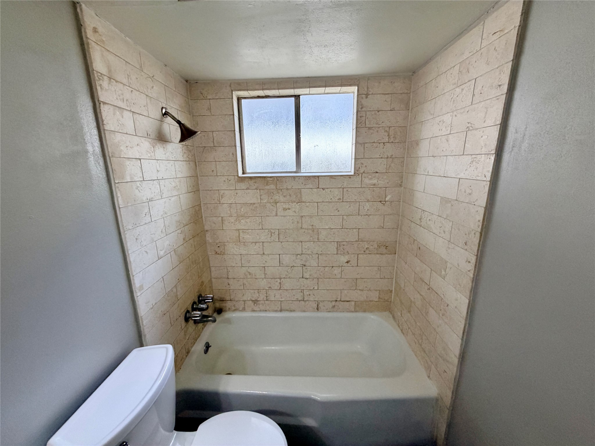 7876 Bender Road Humble, TX 77396 - Photo 25 of 28 a bathroom with a tub toilet and window