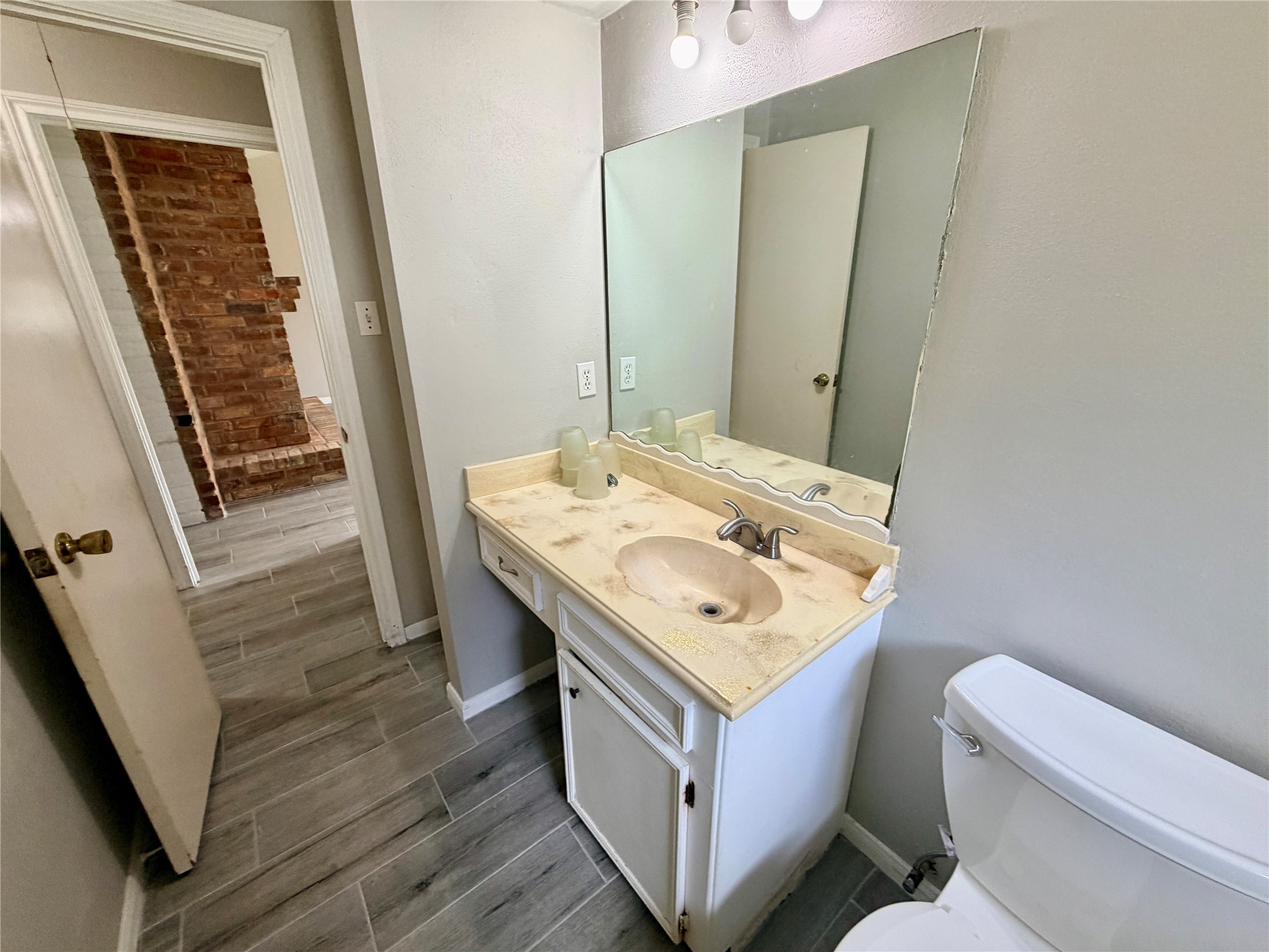 7876 Bender Road Humble, TX 77396 - Photo 26 of 28 a bathroom with a sink a toilet a mirror and vanity