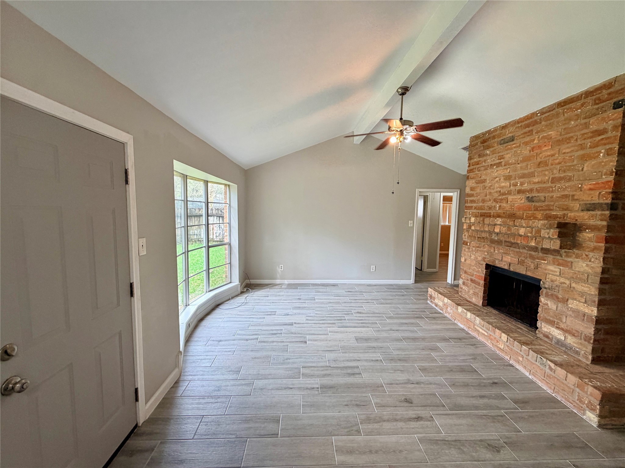 7876 Bender Road Humble, TX 77396 - Photo 4 of 28 a view of an empty room with a fireplace and a window