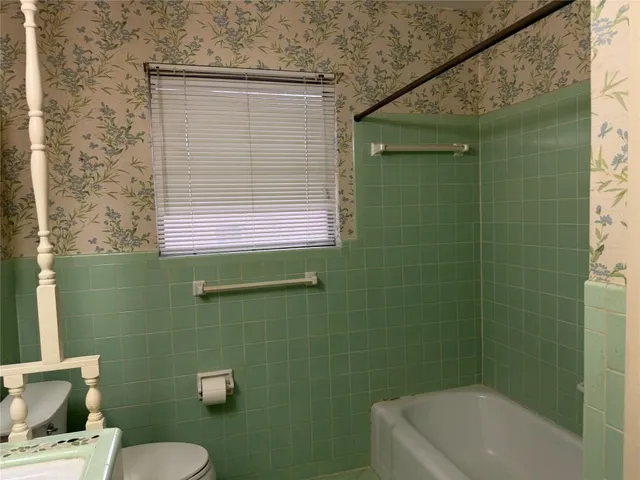 a bathroom with a toilet a sink and bathtub