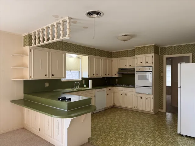 a kitchen with stainless steel appliances granite countertop a sink a stove and a refrigerator
